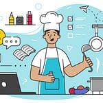 A chef smiles and cooks in a kitchen while looking at a laptop.