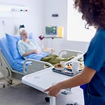 Image of a caregiver delivering a hospital meal through patient room service