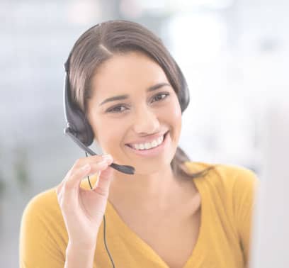 A call center representative grins at the camera as she adjusts her headset.