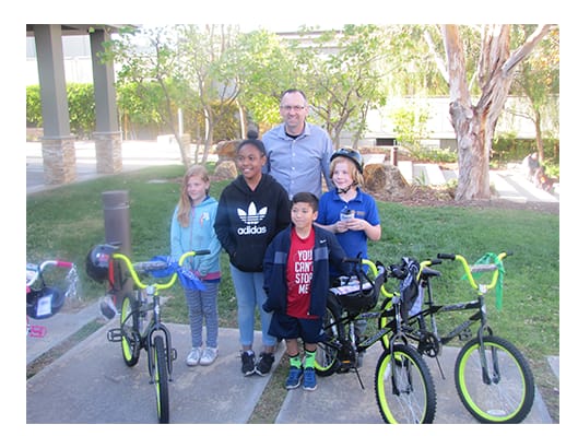 Eric Lipsitt stands with children and bikes for a Boys & Girls Club fundraiser.