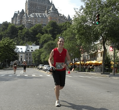 Gen Gagnon is running a marathon in a city street with a large castle in the background.