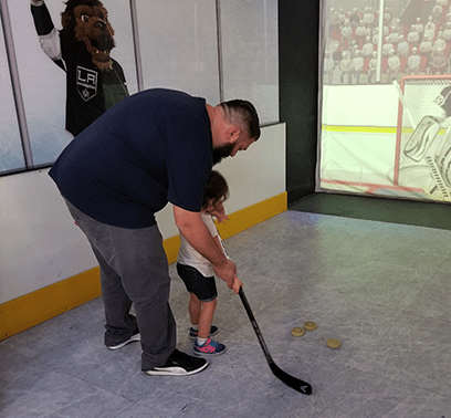 Robert is showing his daughter how to score a goal just like an L.A. King.