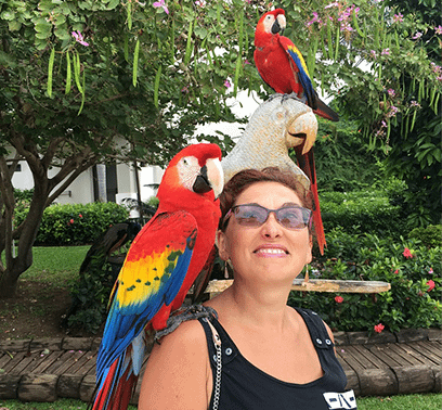Alina being adventurous with three beautiful Scarlett Macaws on her shoulder and head!
