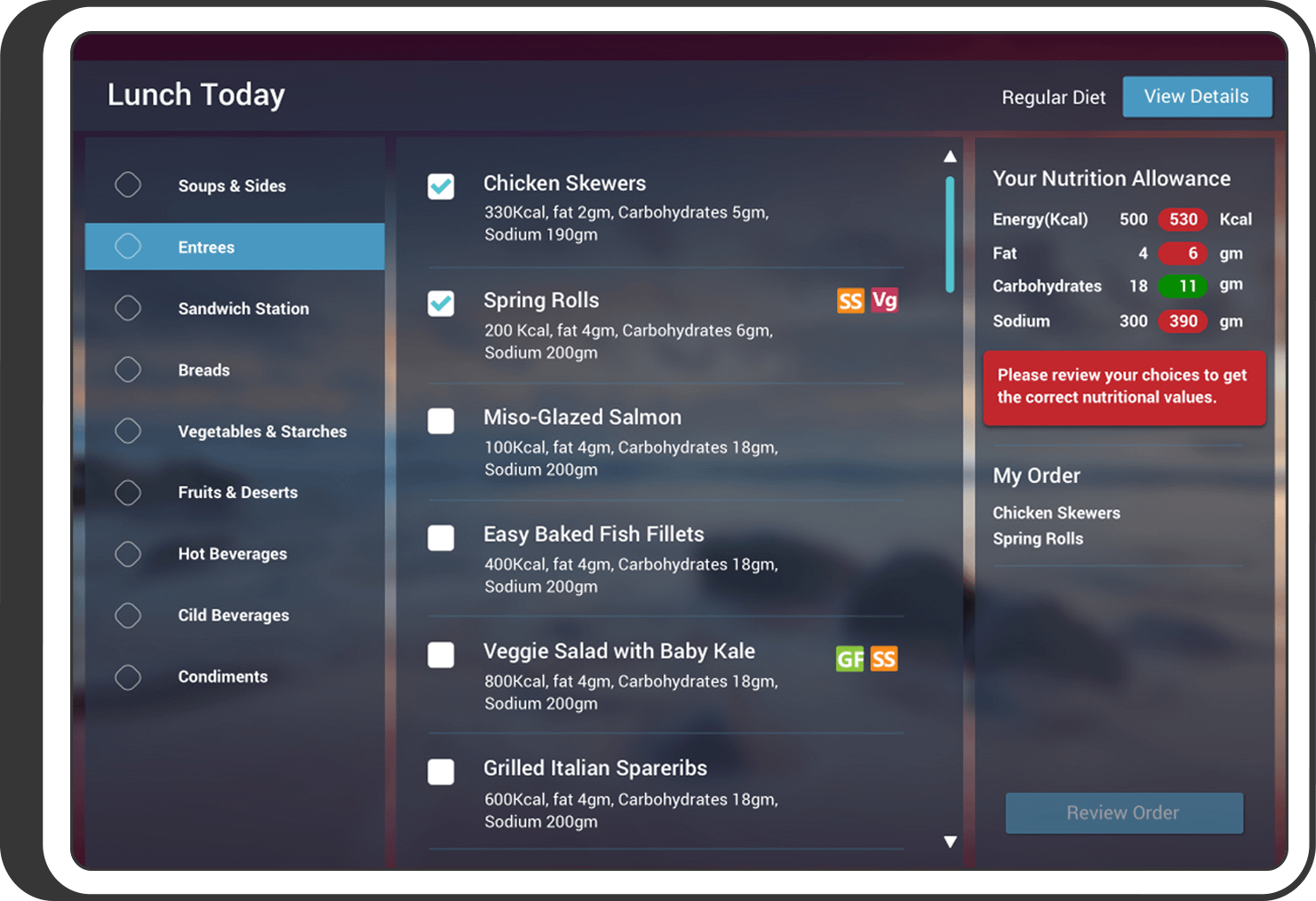 Digital lunch ordering interface showing meal categories on the left and entrée options in the center. Two entrees — Chicken Skewers and Spring Rolls — are selected. Nutritional information is displayed on the right, showing the current selection exceeds recommended energy, fat, and sodium allowances. A red warning message advises users to review their choices.